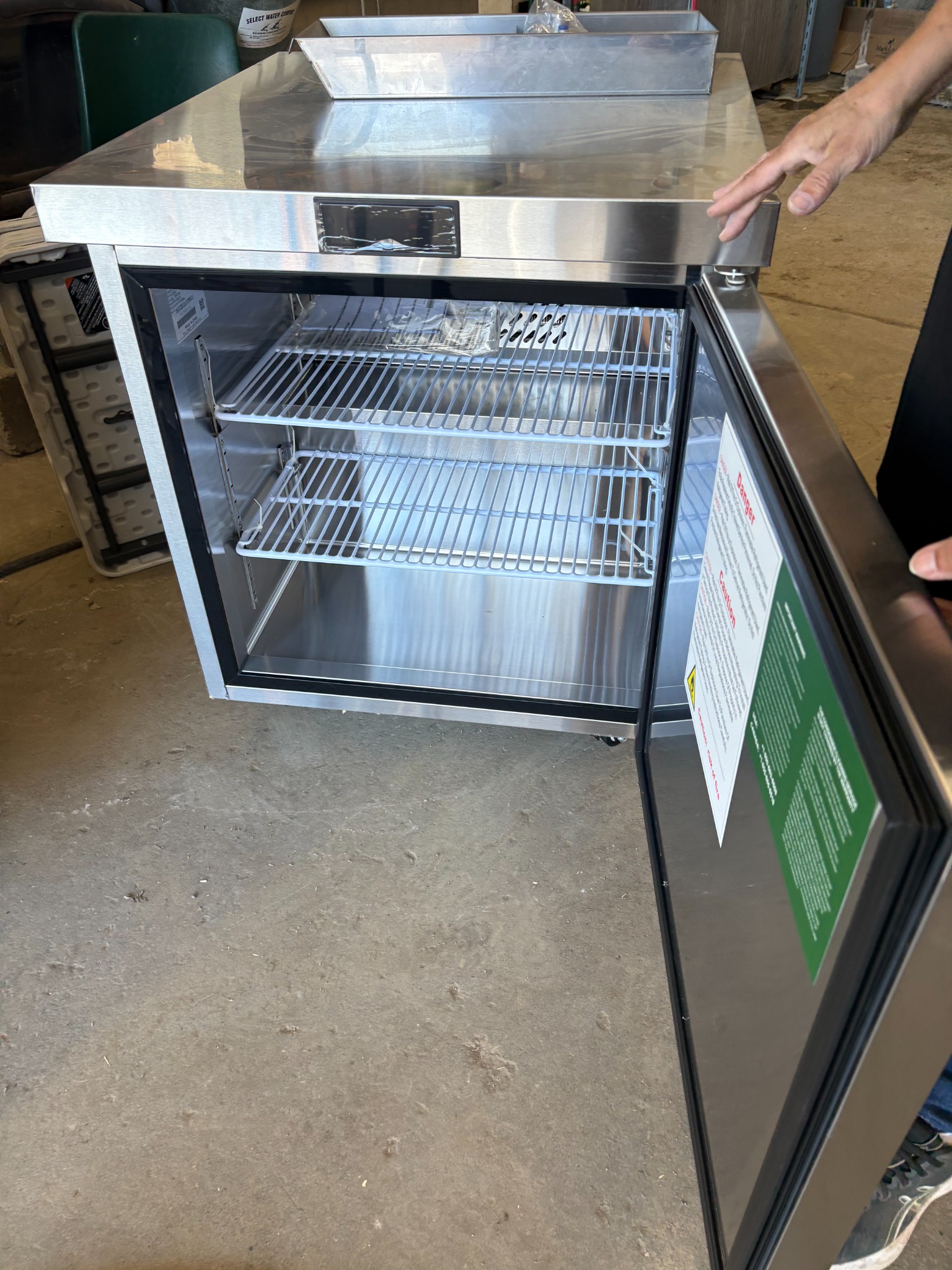 Open stainless freezer in the workshop, not yet installed