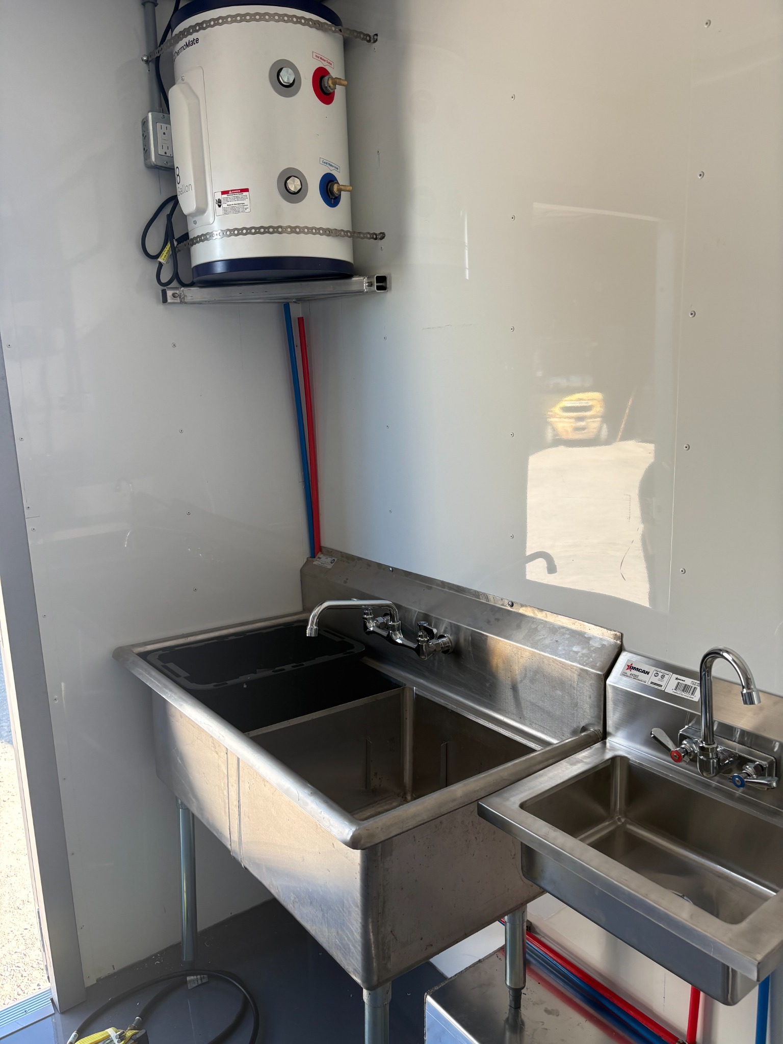 Hot-water heater above the large utensil-washing sinks and smaller handwashing sink