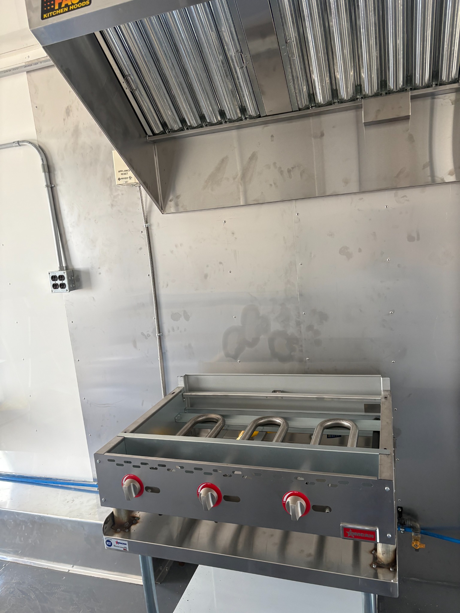 Another angle of the gas grill and commercial exhaust hood